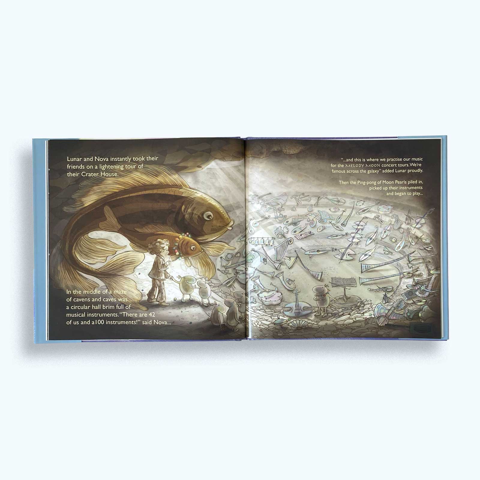 Open book showing illustrations of a giant fish and musical instruments. An orchestra will play in this space. An Orchestra of 'Moon Pearls'.
